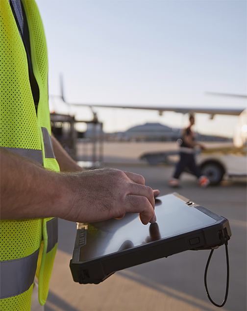 Profissional de logística utilizando tablet em área aeroportuária