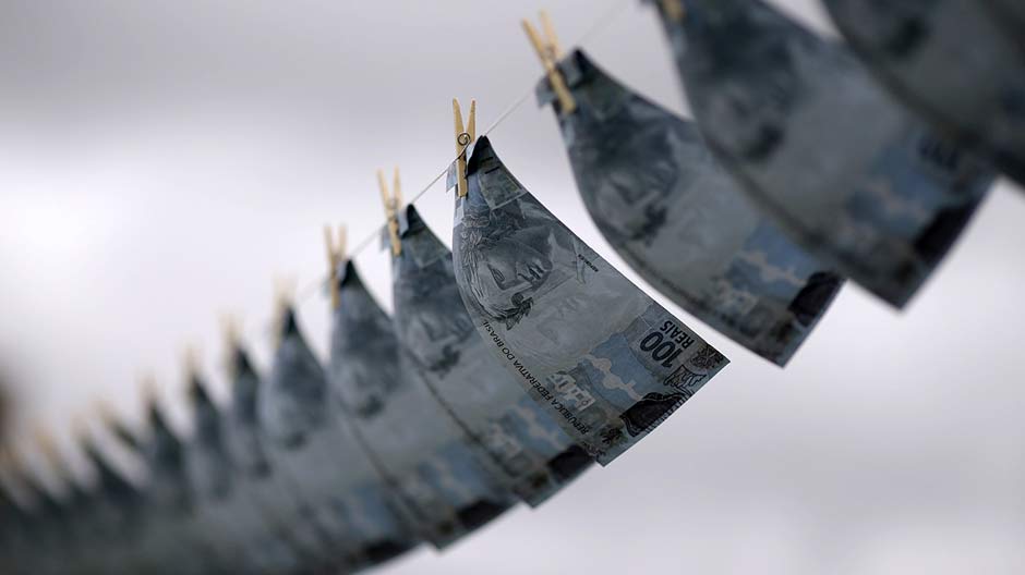 Replicas of R$100,00 banknotes are hung on a clothesline during a protest of the national union of prosecutors against money laundering in Brazil, at the Esplanade of Ministries in Brasilia March 18, 2015.