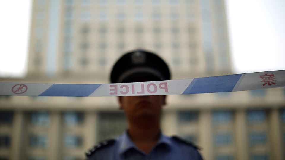 A police officer stands guard at the entrance to the Jinan Intermediate People's Court on the third day of the trial of ousted Chinese politician Bo Xilai in Jinan, Shandong province August 24, 2013.