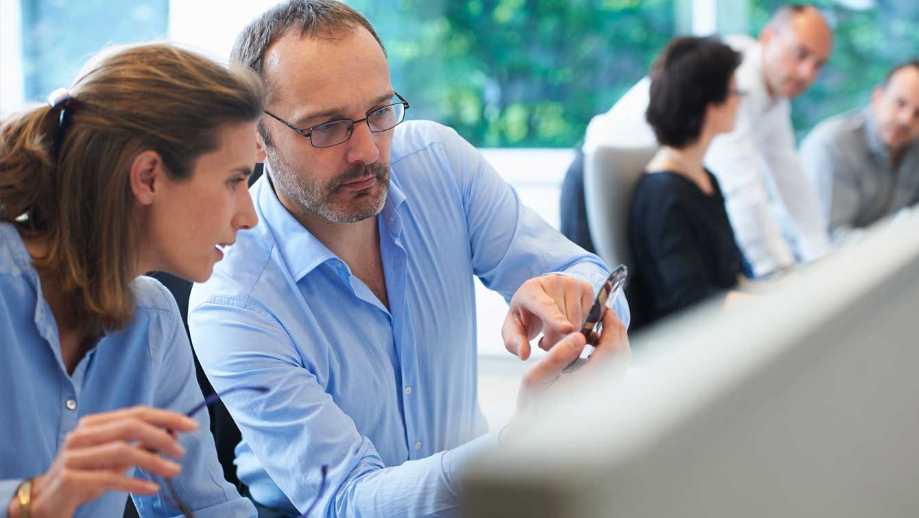 Colleagues looking at mobile phone